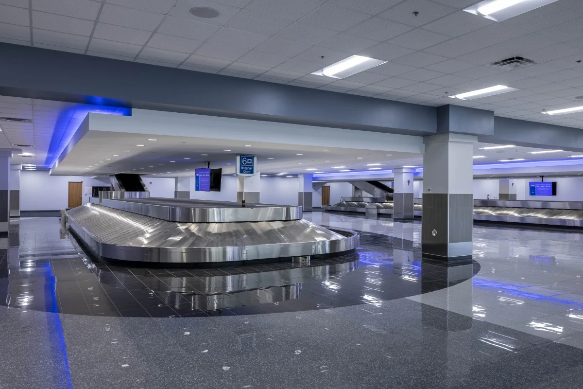 two bag belts in baggage claim area with blue lights