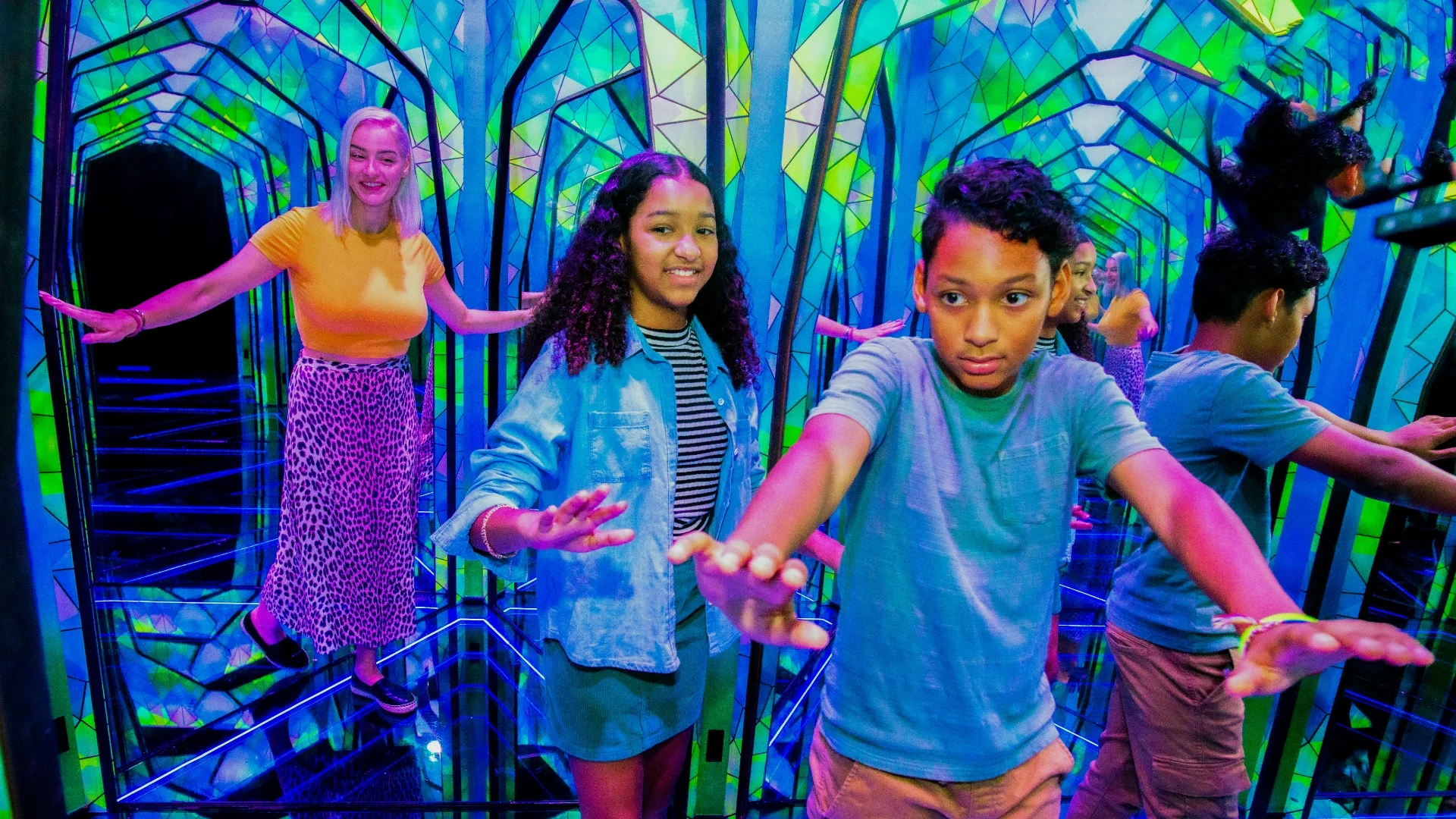 3 people in a colorful mirror maze