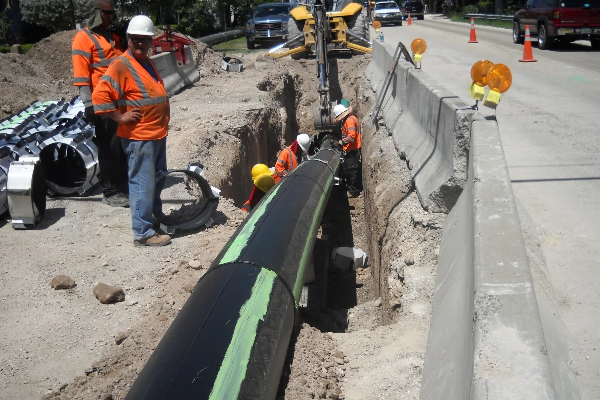 workers in hi-vis laying new piping