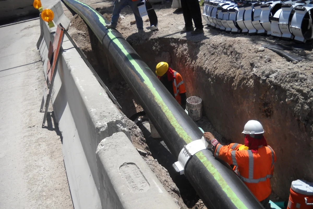 workers in hi-vis laying new piping