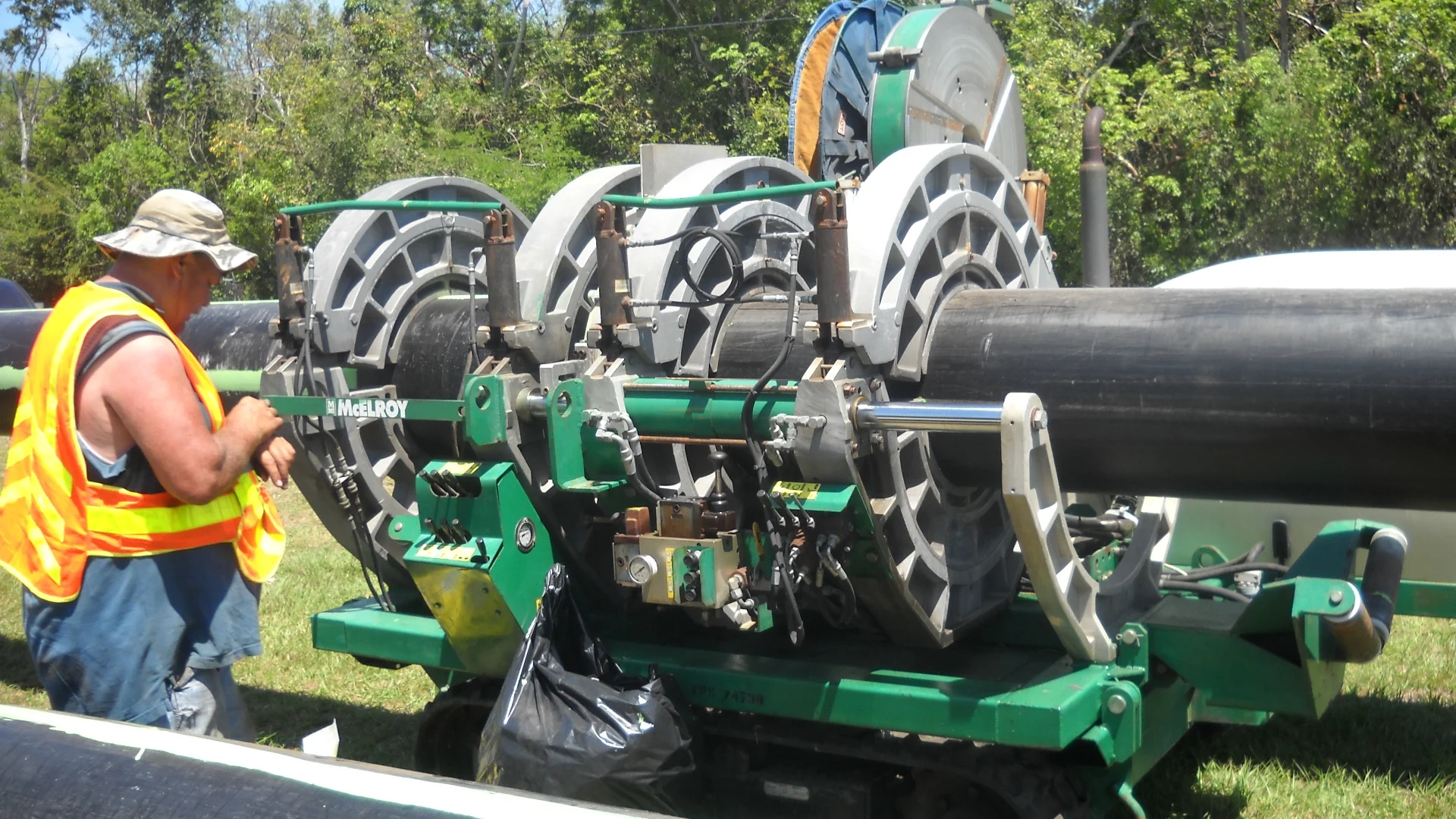 worker in hi-vis with large machinery