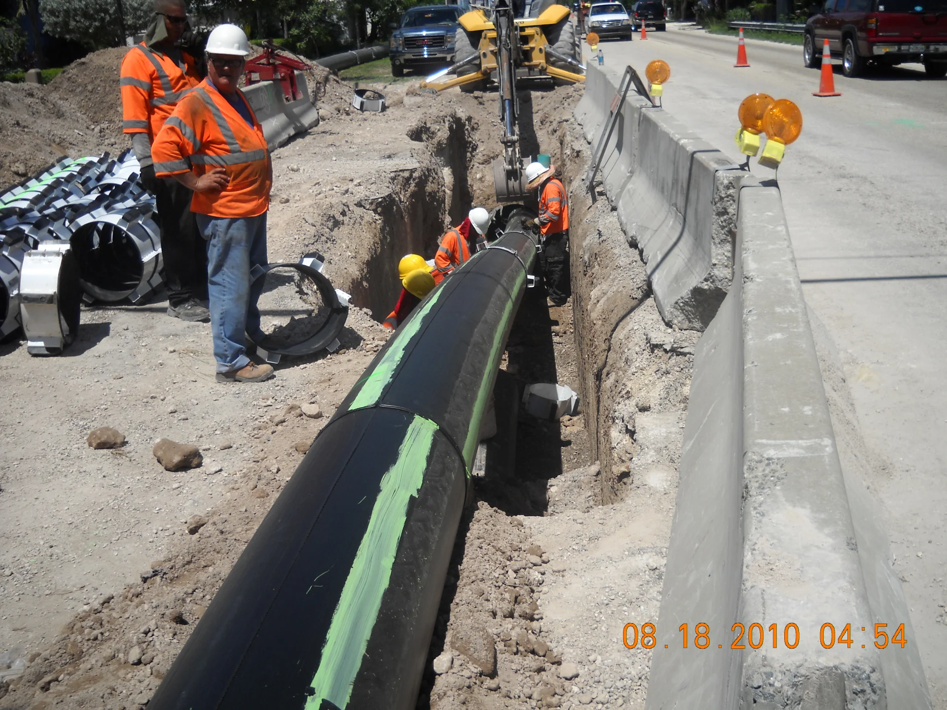 workers in hi-vis laying new piping