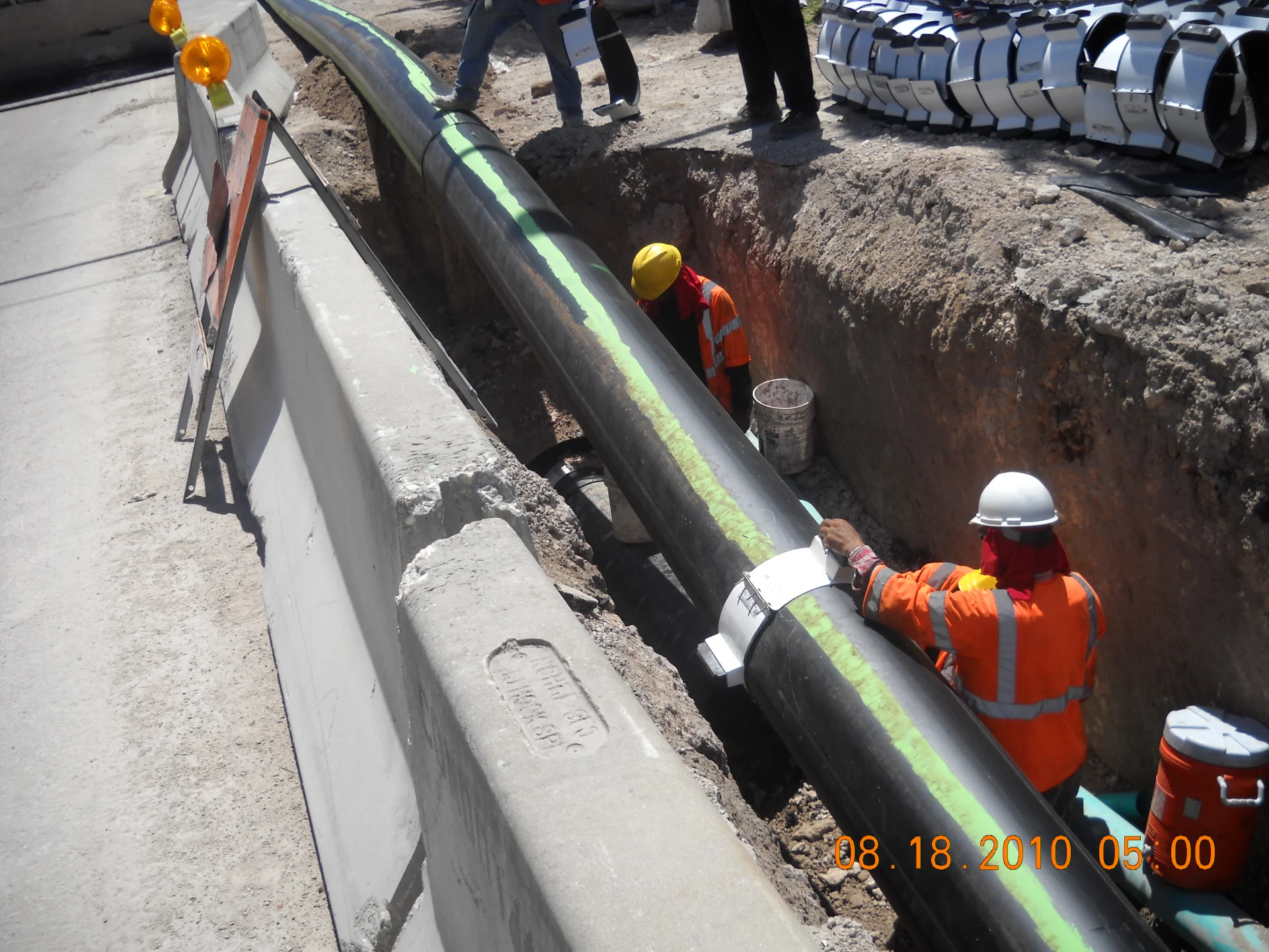 workers in hi-vis laying new piping